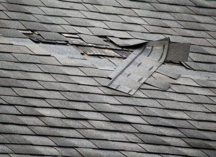 Damaged shingles on a residential roof.