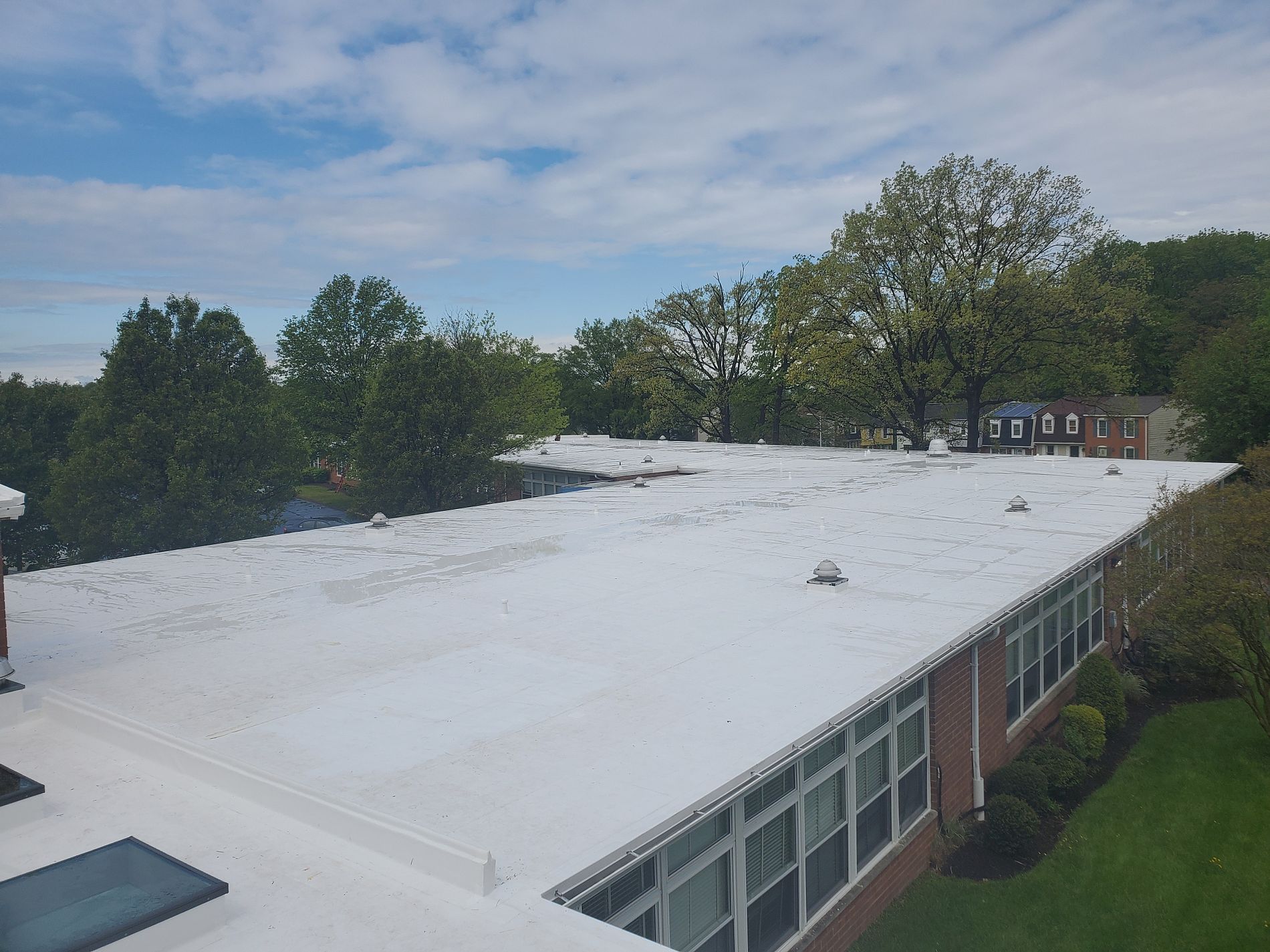Professional roofers applying a roof coating in Gaithersburg's commercial building